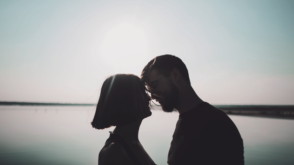 силуэты пары, целующихся на пляже