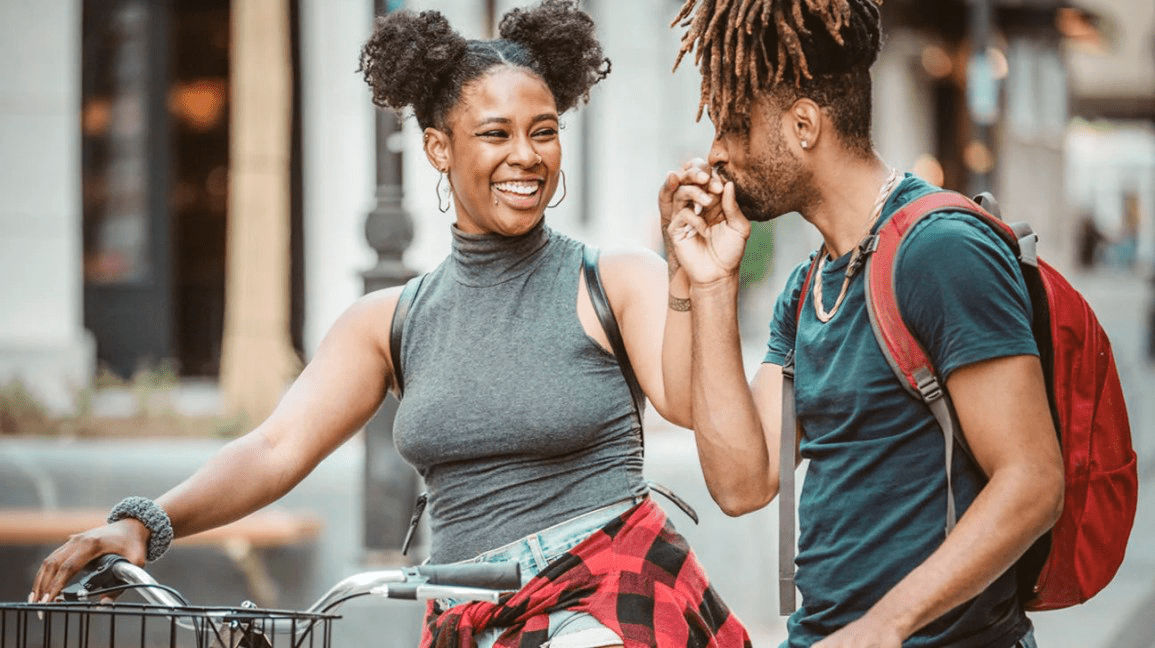 man holding woman's hand and kissing it