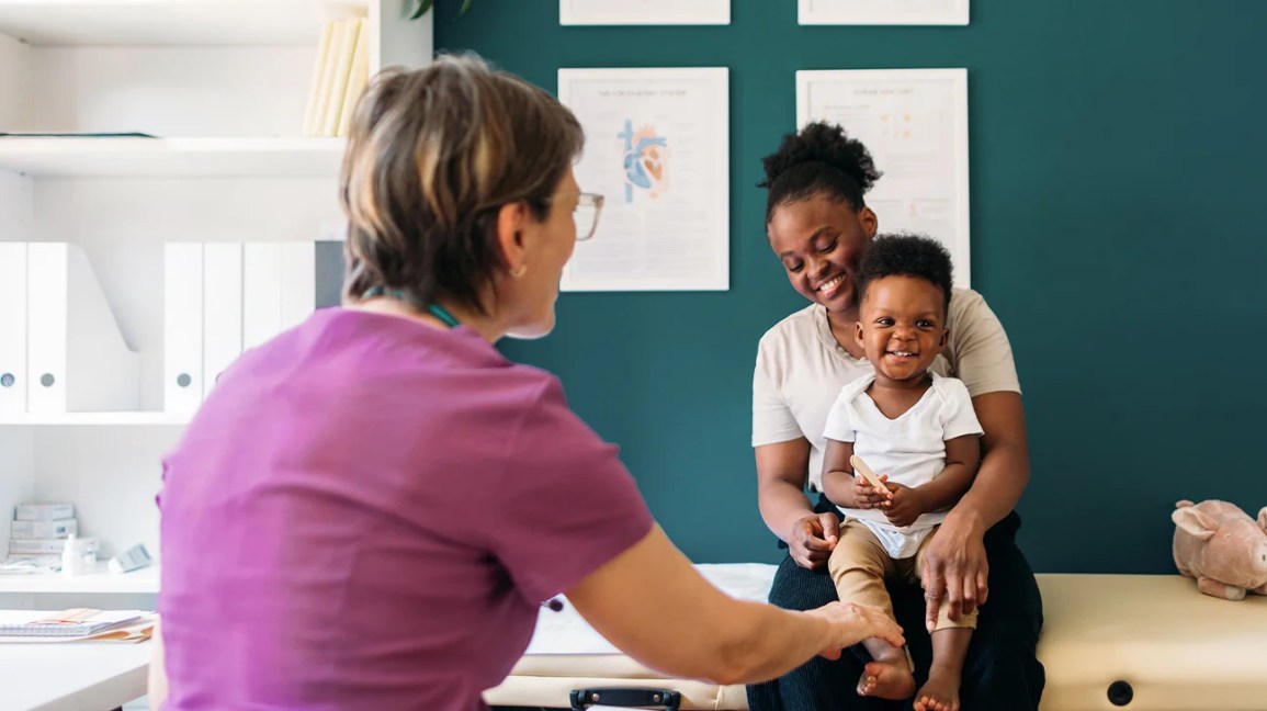 Медсестра оказывает медицинскую помощь матери и малышу в клинике