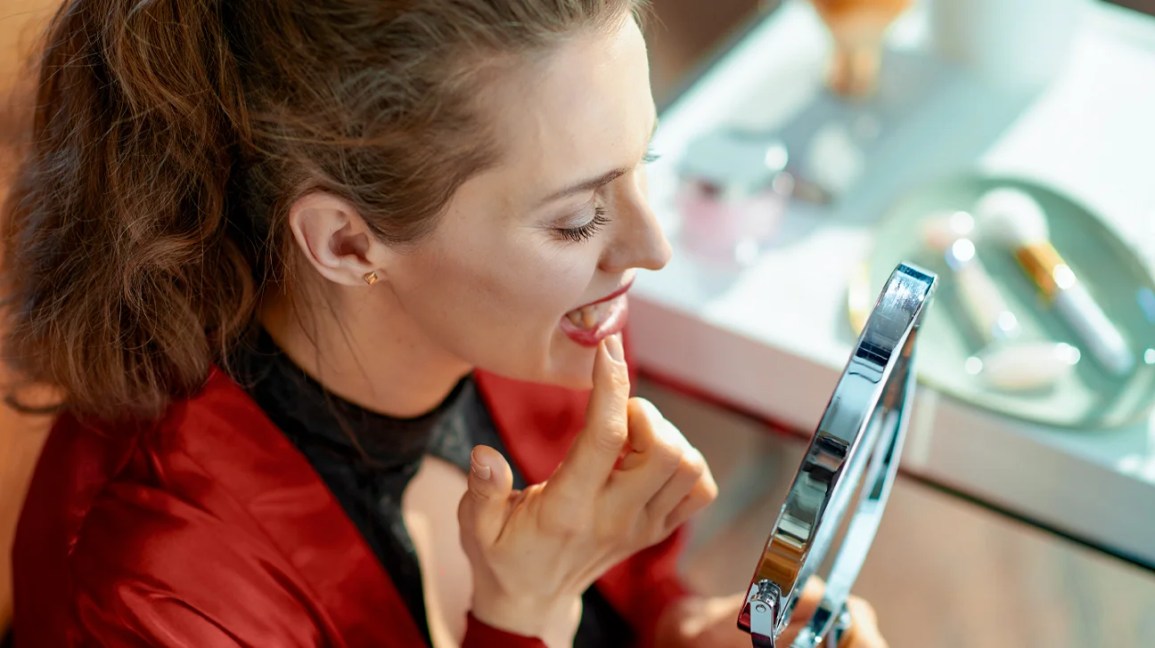 woman examining black triangles between teeth