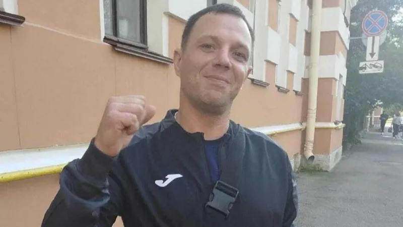 Nikita Khursa A man in a tracksuit pumps the air with one hand while the other, wearing a gold watch, holds a white carrier bag