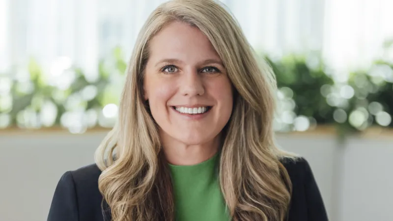 MODerna Tracey Franklin smiling wearing a dark jacket and green shirt