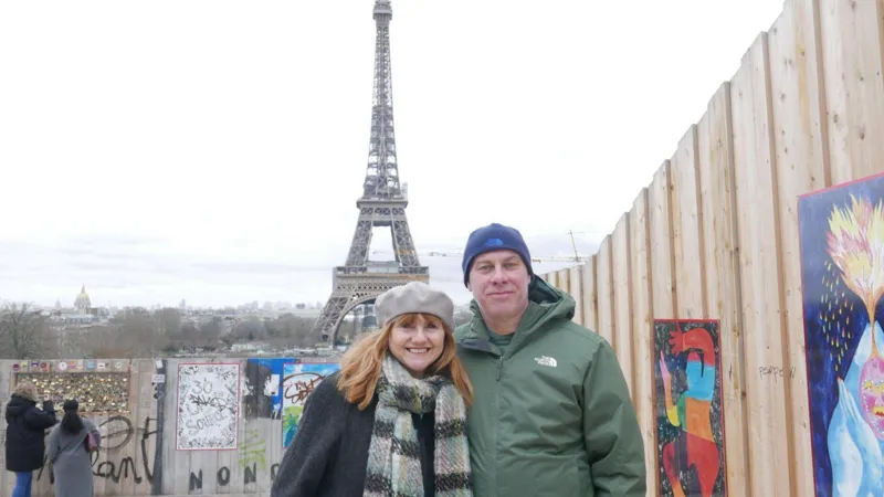 John Starns Phillipa and John Starns in winter coats and hats standing posing in front of the Eiffel Tower in Paris 