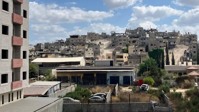 Empty buildings and bulldozer-created roads are seen in the distance