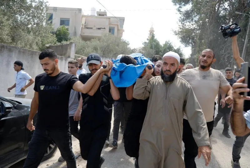 Reuters Mourners carry a body wrapped in a blue shroud on a stretcher