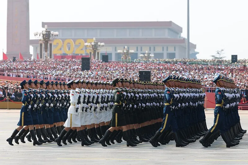Getty Images Soldiers in ceremonial uniform march in front of a crowded podium
