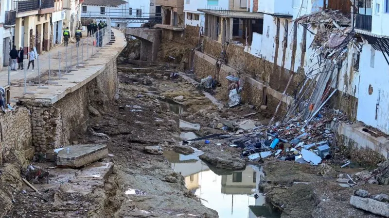AFP via Getty Images Debris lies in the river next to destroyed houses in Chiva, in the region of Valencia, eastern Spain, in the aftermath of catastrophic deadly floods on November 19, 2024