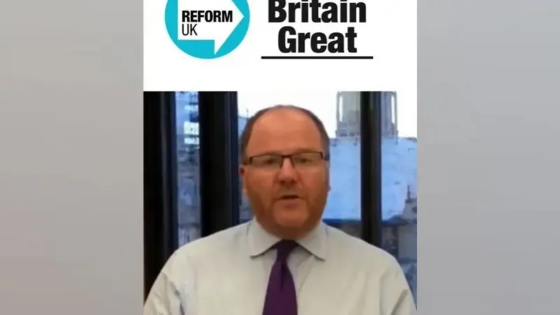 Facebook This is a snapshot taken from the deepfake video. A man who appears to be George Freeman is sitting in front of a window, talking directly to the camera. He is wearing a shirt and tie, and glasses. Above him is the Reform Party logo and the words 