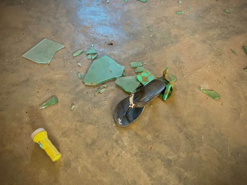 Gift Ufoma / INLIBER A sandal next to a torch and broken pieces of glass in a dormitory with beds at St Mary's boarding school in Papiri village in Niger state.