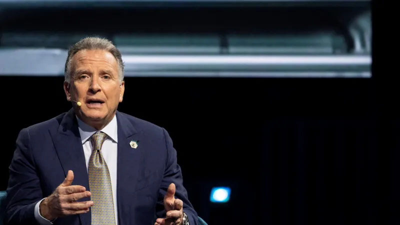 Reuters A middle-aged man in a blue jacket, white shirt and gold tie gesticulates in a room.