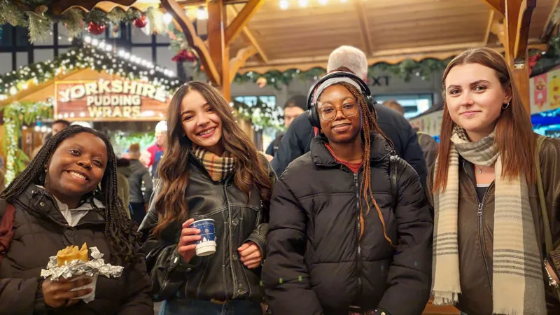 Four women at a Kingston market stall with mulled wine and wraps
