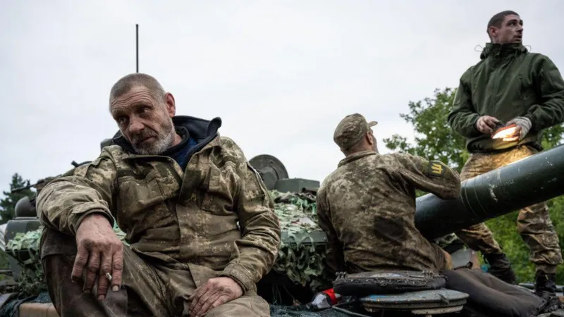 Getty Images Ukrainian soldiers in full battle dress on a muddy field