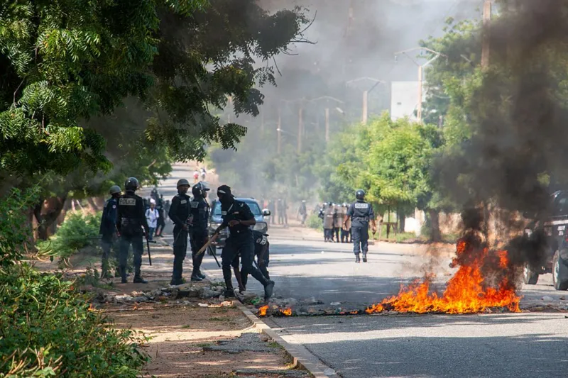 AFP via Getty Images Police and protesters in Cameroon