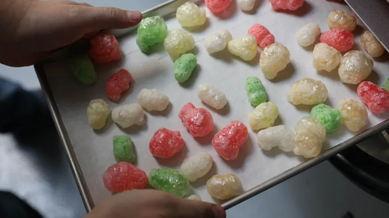 Getty Images A tray of freeze dried sweets being pulled out of an oven. The look like a puffed-up version of gummy bears.