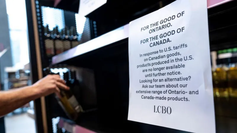 Worker removing US liquor from Ontario shelves