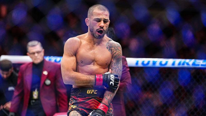 Alexandre Pantoja grips his injured arm after defeat by Joshua Van