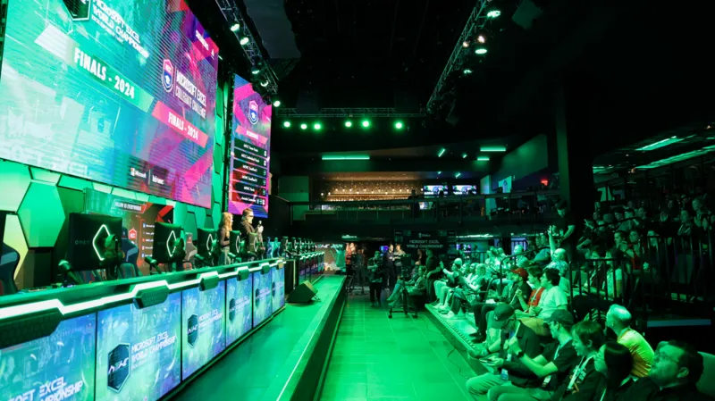 Аудитория MEWC и финалисты на арене в зелёной подсветке.