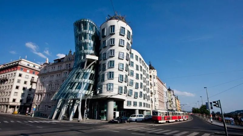 Prague Dancing House viewed from street with a tram