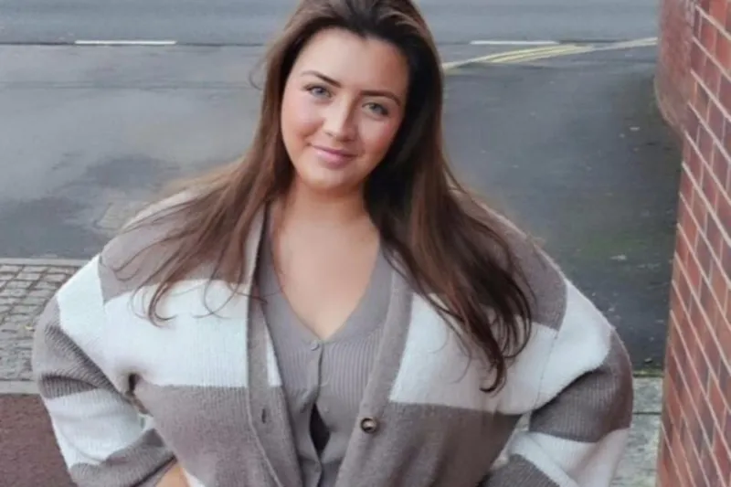 Melissa Grey va oq-qizil tasvirli kiyingan holda turmoqda