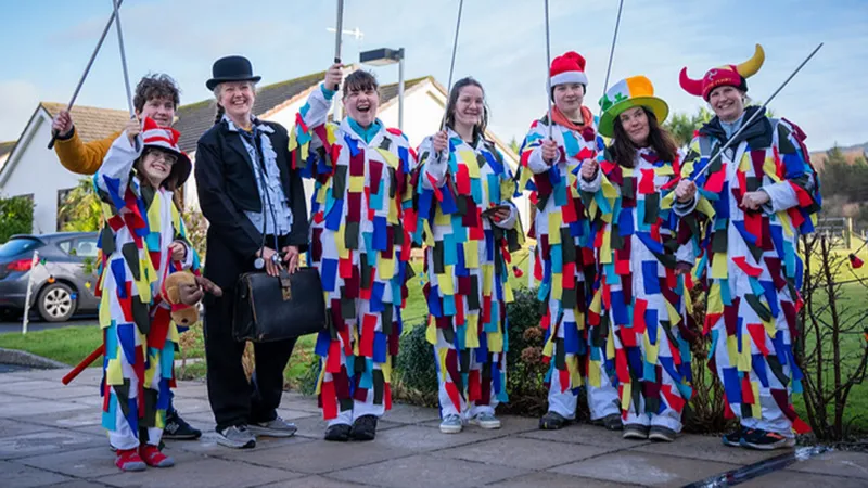 Oq kiyimli guruhlar rangli lenta bilan tegingan muskullar, yuqorida yumshoq yigitlar va ayol kishi yoqimli tabassum bilan rasmga tushmoqda