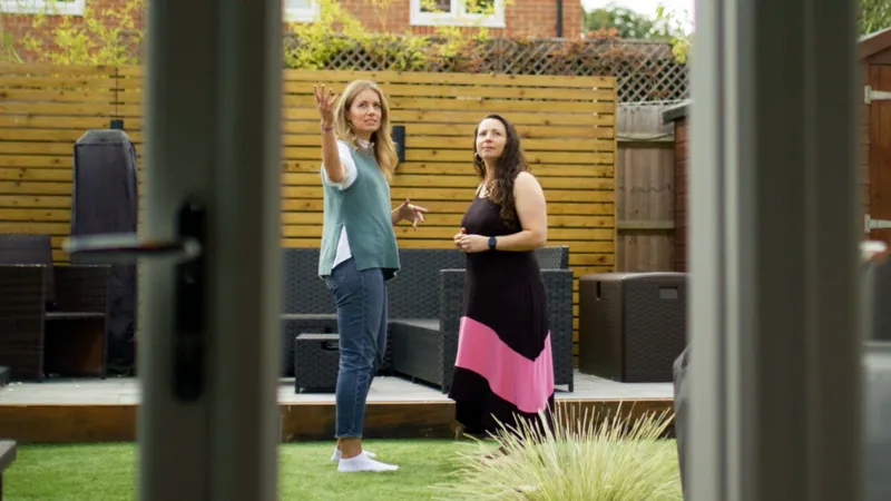 Two women in a garden discussing health.