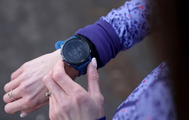 Kristian Johnson/INLIBER A close-up of a woman checking her smart watch by pressing buttons and looking at statistics showing up on the screen.
