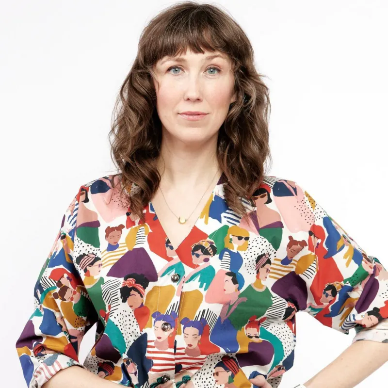 Bergen Anderson kameraga qarab turadi; nozik surat, sochlari va kiyimini ko‘rsatadi