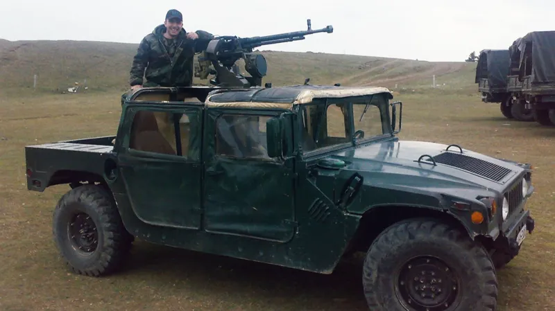 Лаша Шергелашвили в военной форме, рядом бронетранспортер