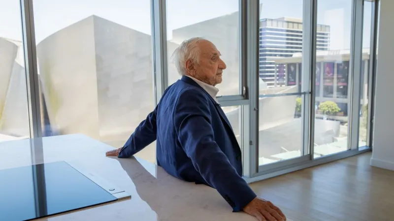 Jay L. Clendenin / Los Angeles Times via Getty Images Frank Gehry has his back to the camera as he stands at a kitchen island within his personal apartment at The Grand by Gehry development in Los Angeles