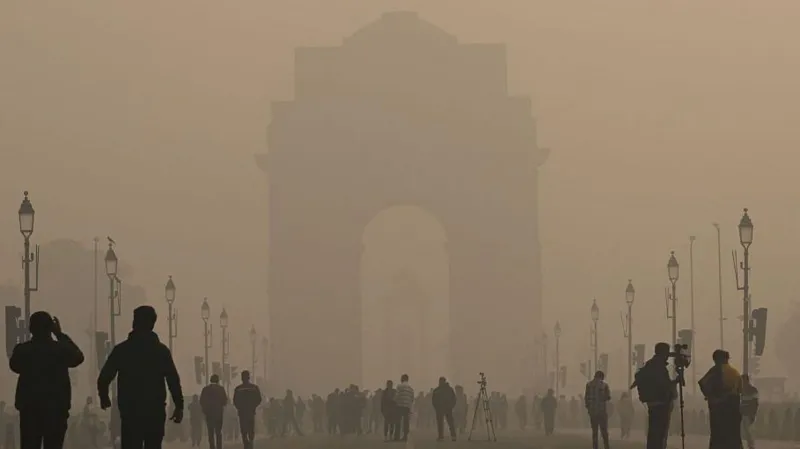 Getty Images Morning smog seen in Delhi's Kartavya Path on 14 December 2025, as the view of the India Gate seems to get blurred because of haze, even as people walk around the area in the daytime
